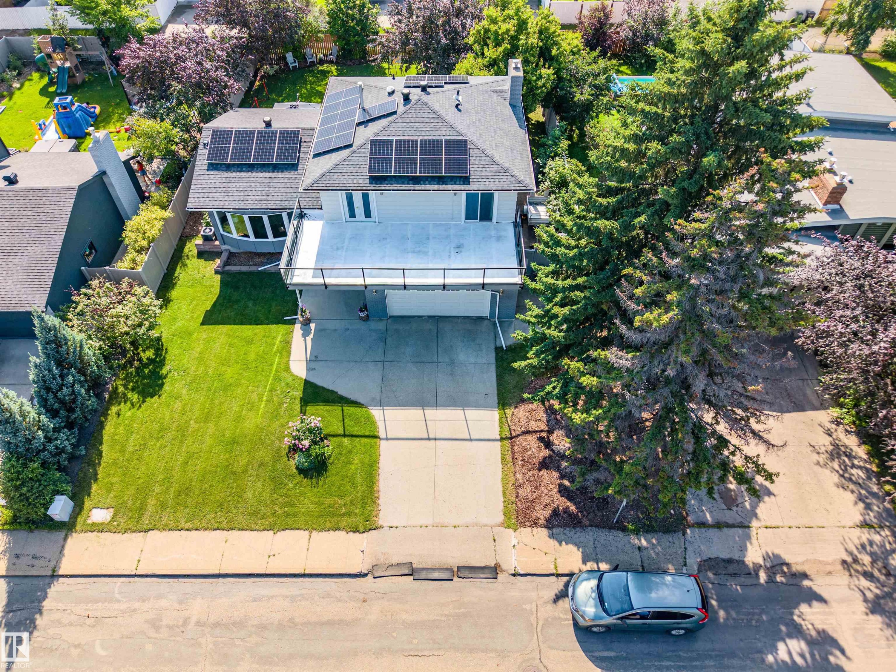 Two-story residence featuring a front-facing garage and an upper-level balcony with a glass railing - 5212 142 Street Nw, Edmonton, AB
