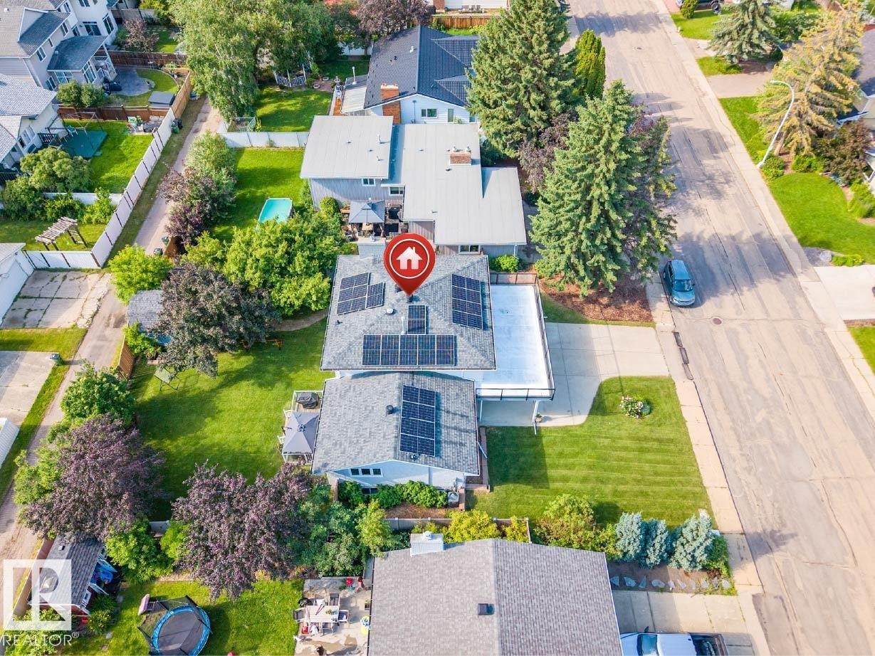 Residential property featuring a grey shingle roof with multiple solar panels - 5212 142 Street Nw, Edmonton, AB