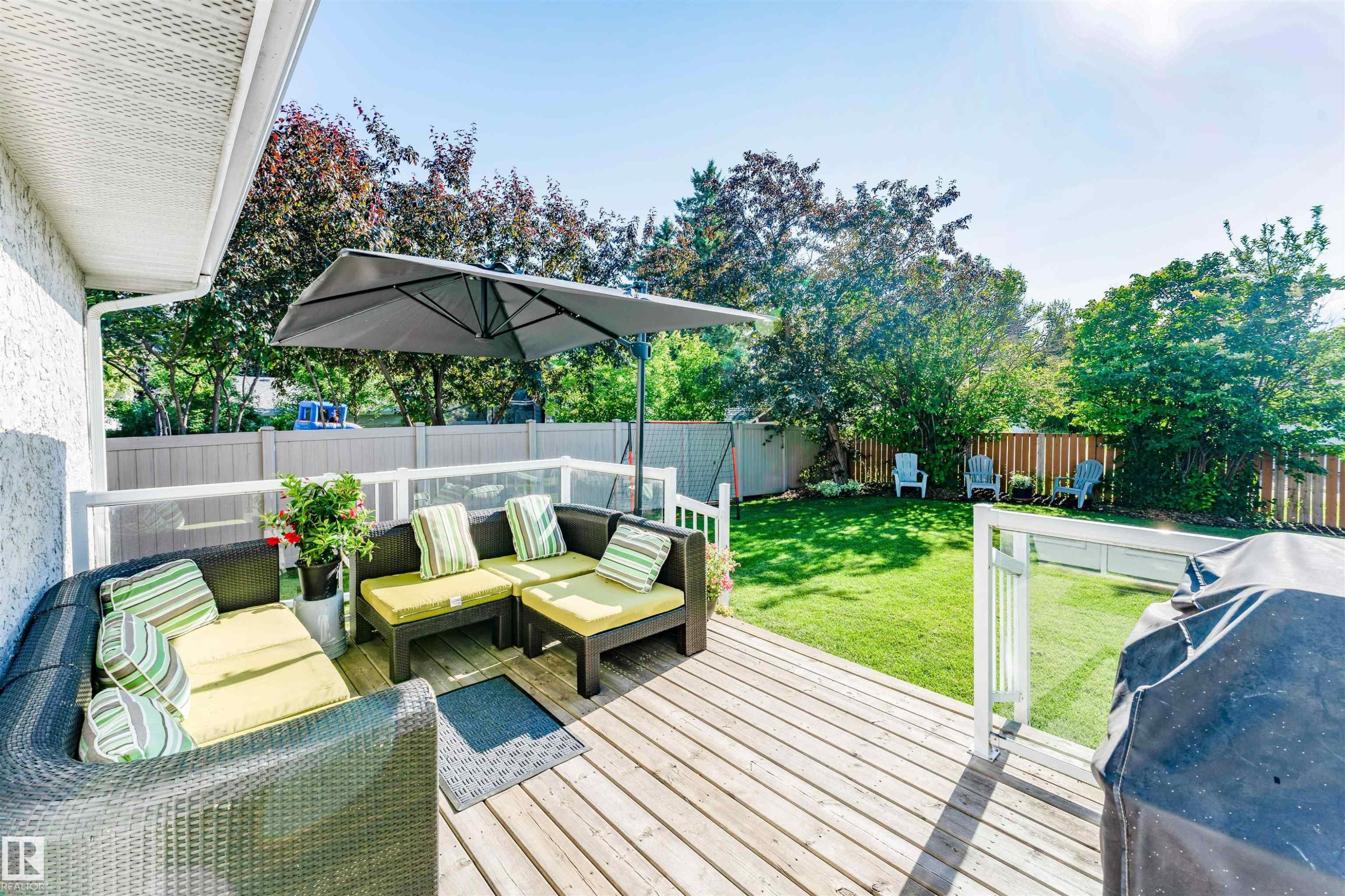 Expansive wood-plank deck with white railings and clear panels - 5212 142 Street Nw, Edmonton, AB
