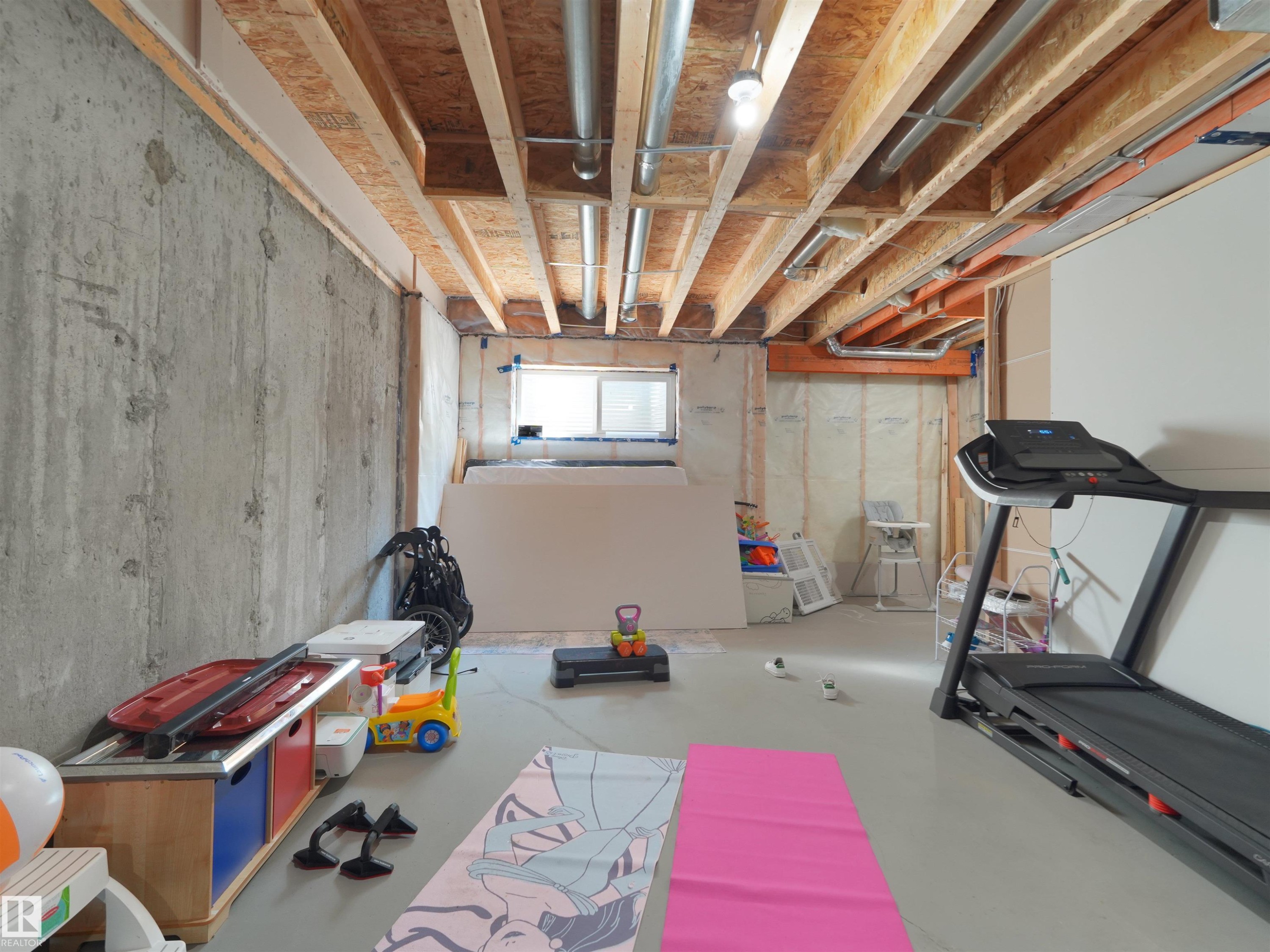 Unfinished basement space featuring exposed concrete walls and ceiling joists - #30 4137 76 St Nw, Edmonton, AB