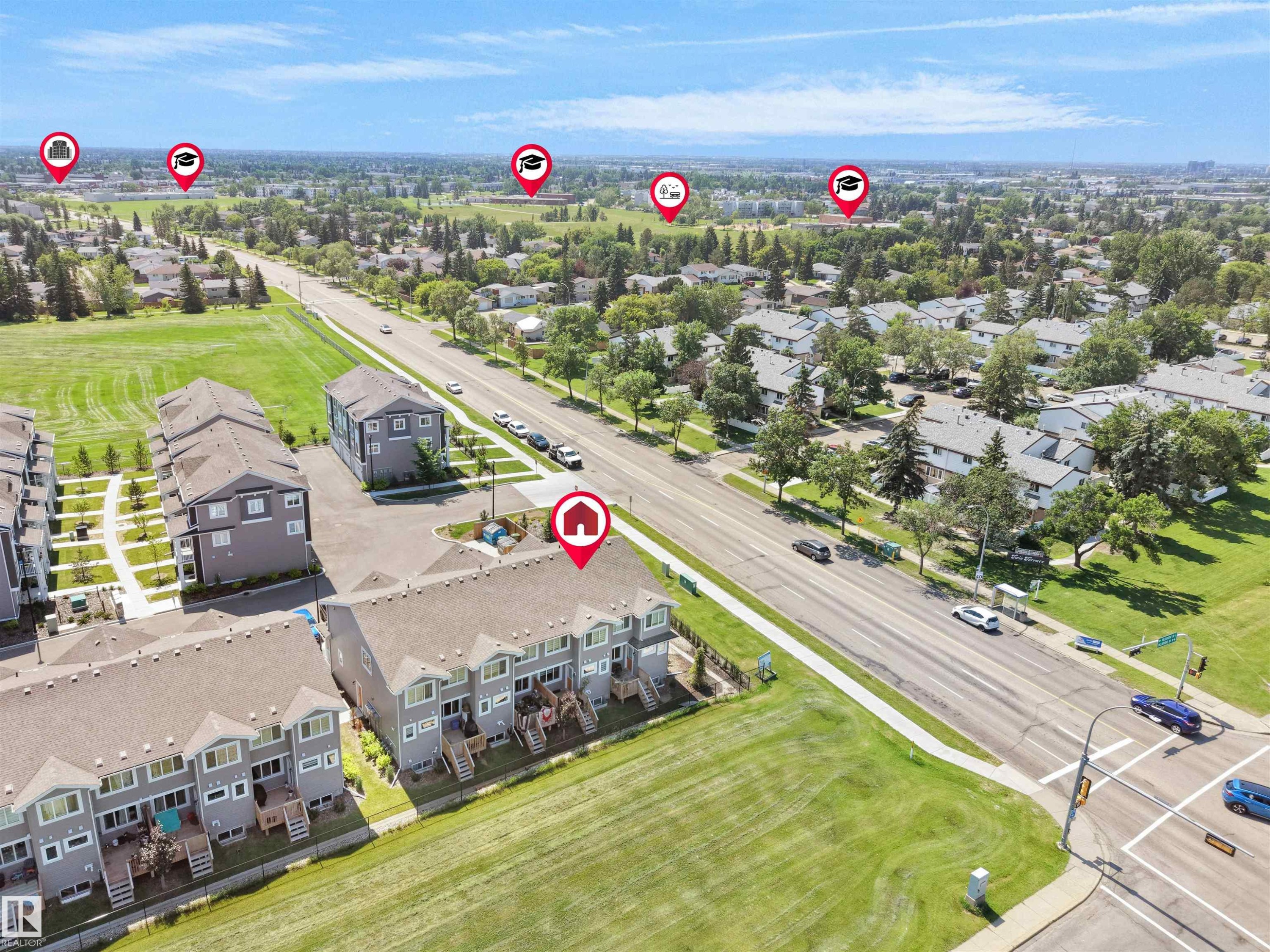 Aerial view of a residential area featuring multi-story townhomes with light gray siding and brown shingled roofs - #30 4137 76 St Nw, Edmonton, AB