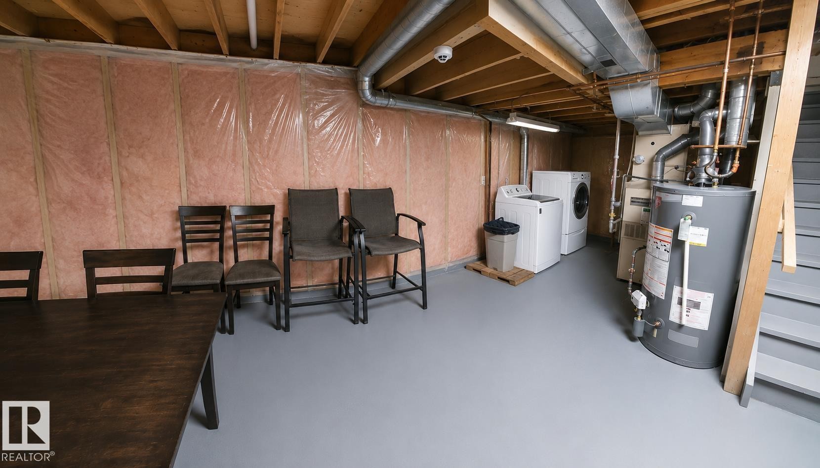 Unfinished basement space featuring exposed wood joists, insulated walls, and painted concrete flooring - 1022 106 Street Nw, Edmonton, AB - Indoor Photo Showing Basement