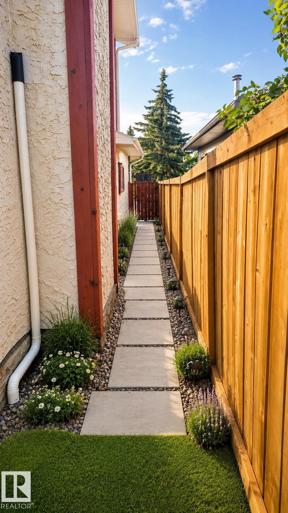 Side yard featuring a stepping stone pathway, decorative gravel, and low-maintenance landscaping - 1022 106 Street Nw, Edmonton, AB - Outdoor With Exterior