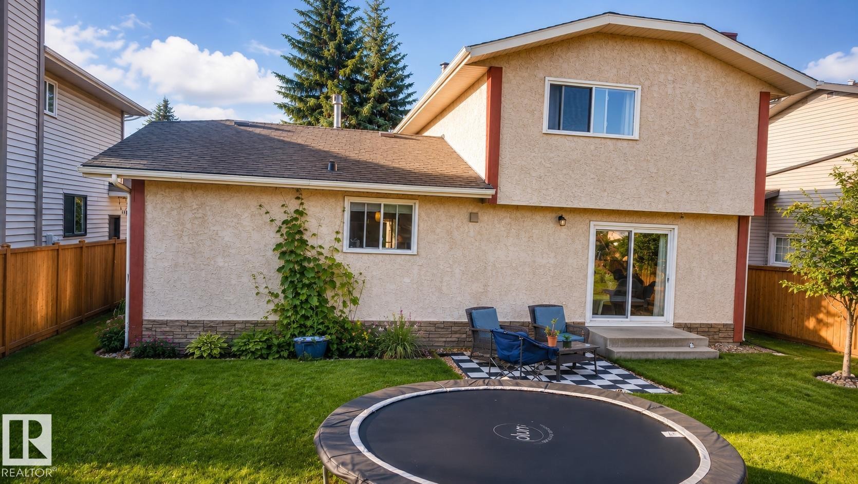 Manicured lawn surrounding a stucco exterior with stone veneer accents - 1022 106 Street Nw, Edmonton, AB - Outdoor