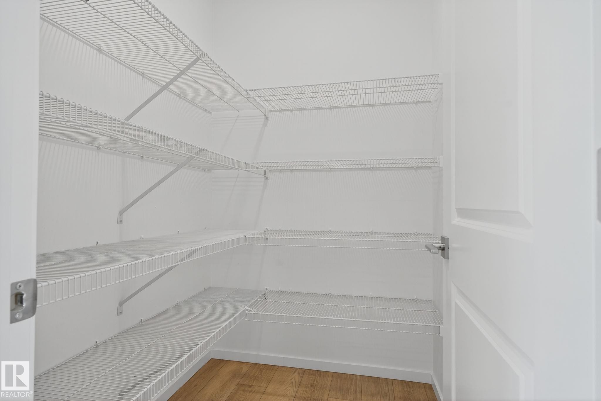 Walk-in storage closet featuring multiple tiers of white wire shelving, extending along two walls - 264 Orchards Boulevard Sw, Edmonton, AB - Indoor With Storage