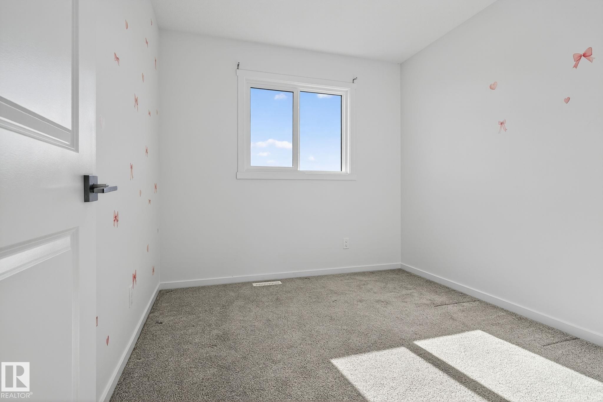 Neutral-toned carpet flooring complements light wall finishes - 264 Orchards Boulevard Sw, Edmonton, AB - Indoor Photo Showing Other Room