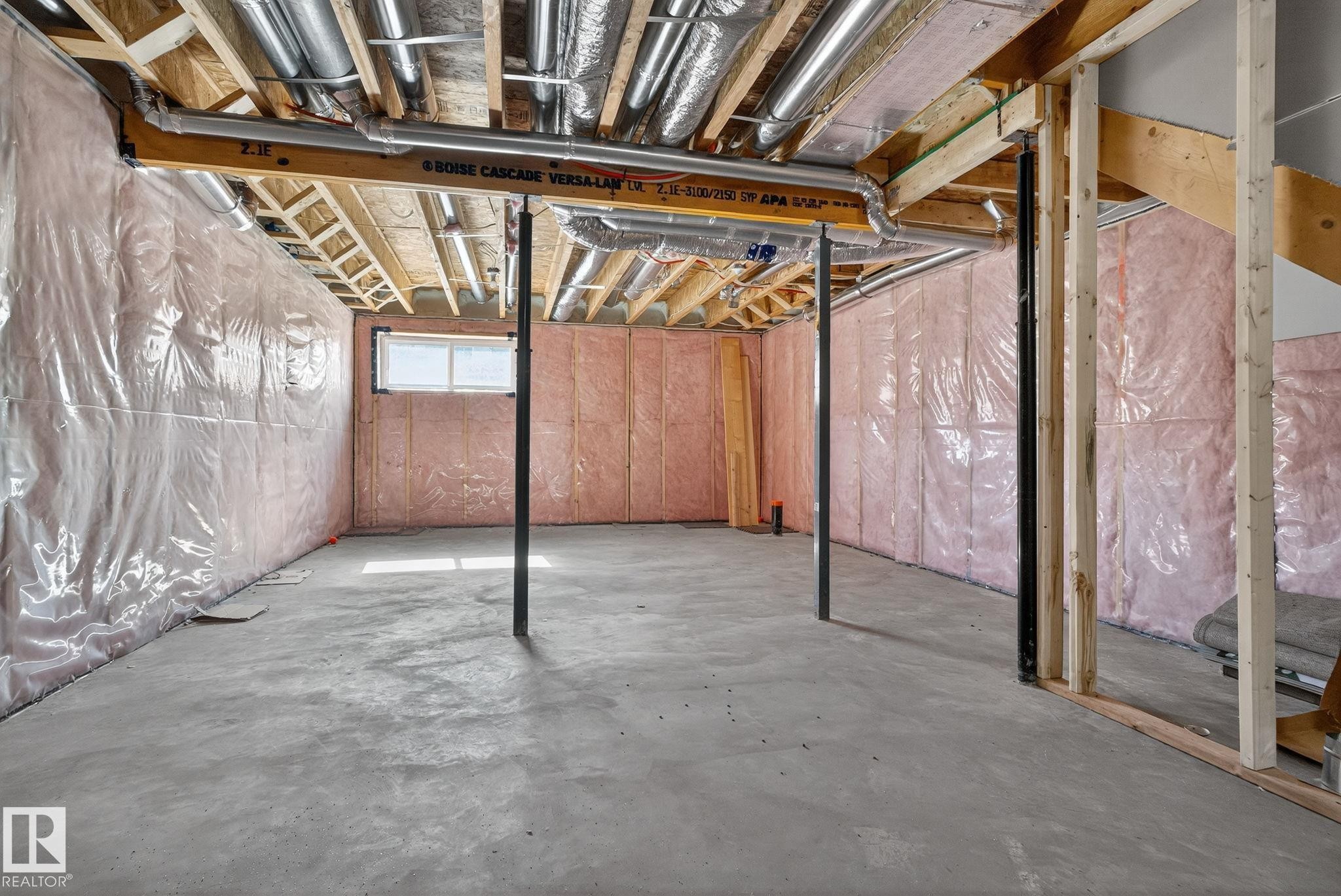 Unfinished basement with concrete flooring, exposed ceiling joists, visible insulation, and a single window - 264 Orchards Boulevard Sw, Edmonton, AB - Indoor Photo Showing Basement