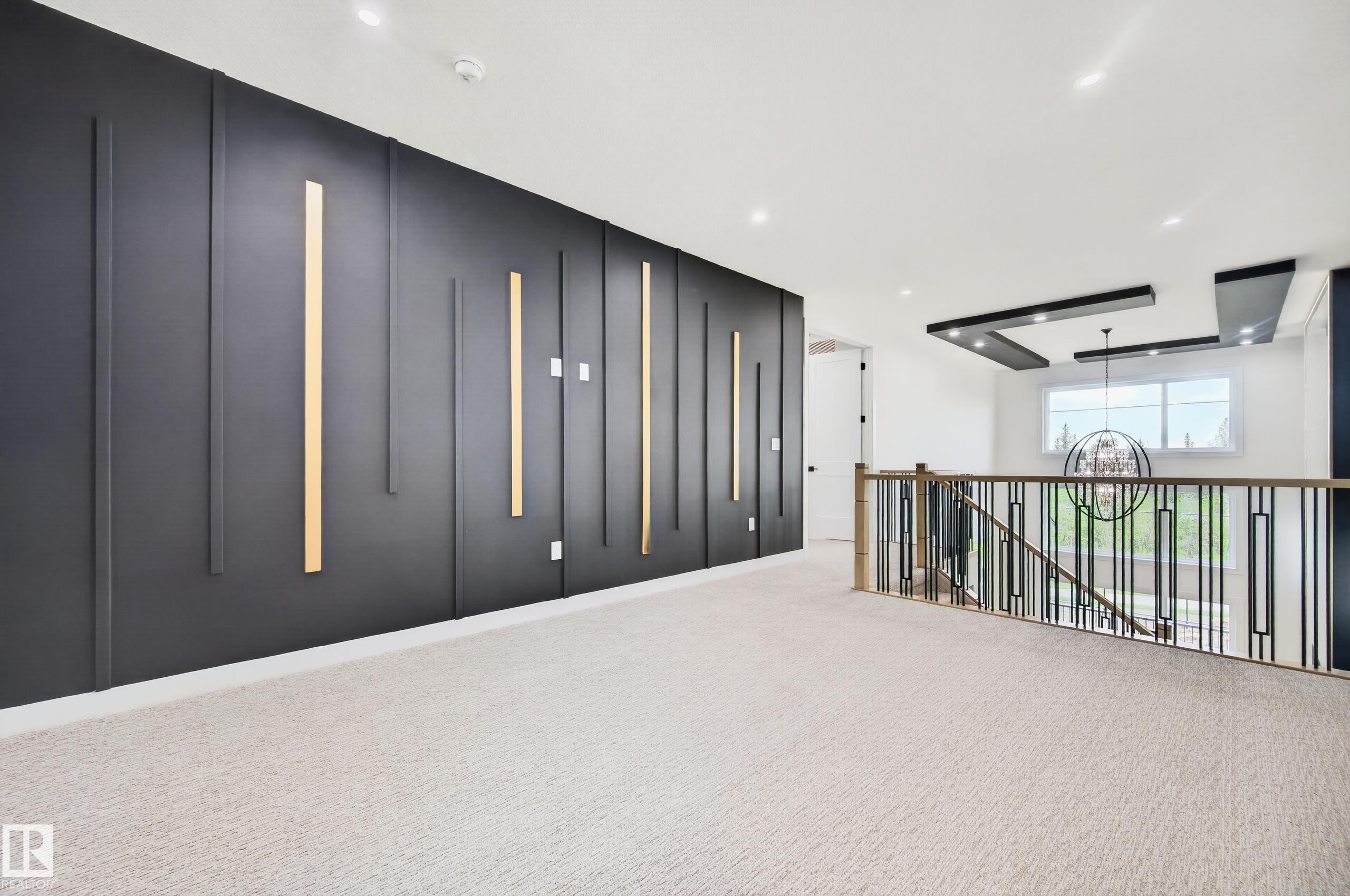 Spacious upper-level landing featuring a contemporary accent wall with vertical paneling and integrated lighting - 431 172 Avenue, Edmonton, AB - Indoor Photo Showing Other Room