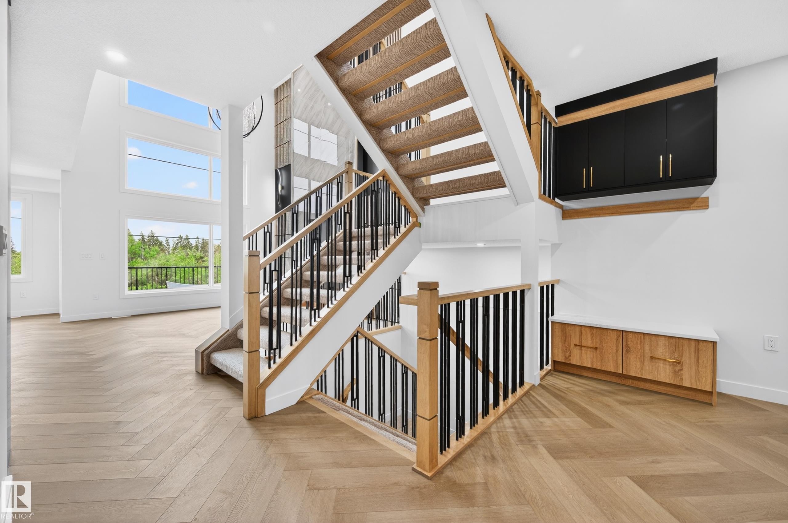 Two-story staircase featuring wood newel posts, black metal balusters, and carpeted treads - 431 172 Avenue, Edmonton, AB - Indoor Photo Showing Other Room