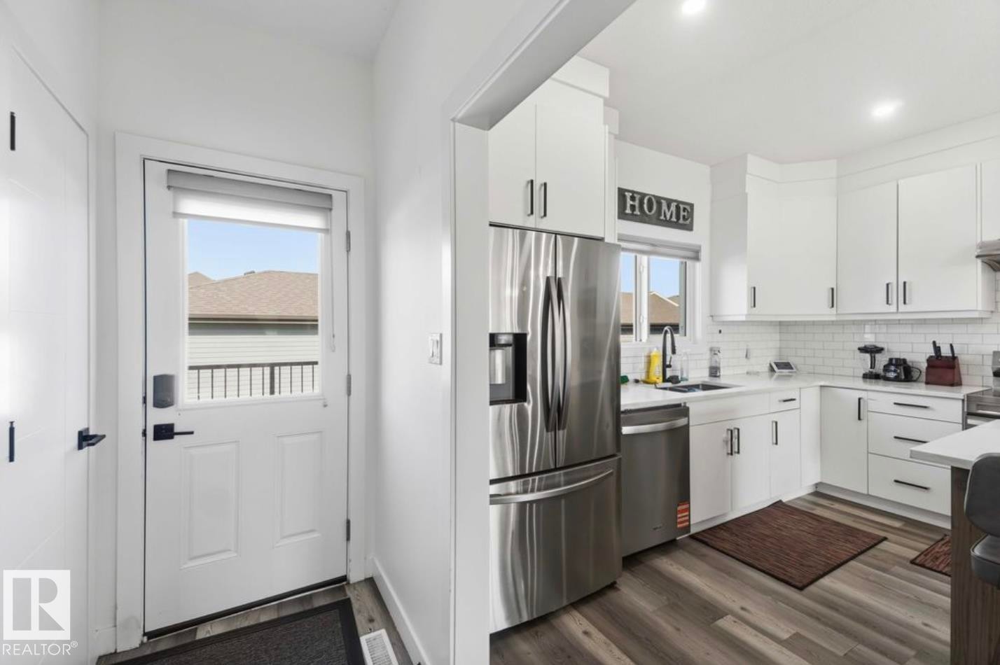 Modern kitchen featuring white cabinetry, stainless steel appliances, and wood-finish flooring - 17924 61 Street Nw, Edmonton, AB - Indoor Photo Showing Kitchen With Stainless Steel Kitchen