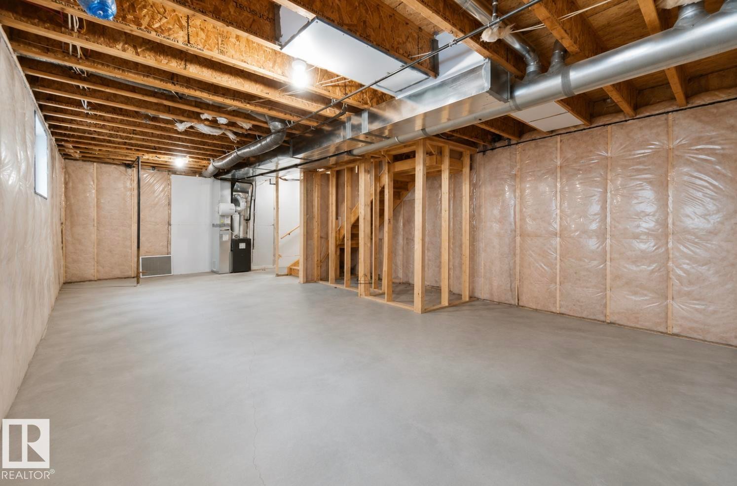 Unfinished basement featuring exposed wood joists, concrete flooring, and insulated walls - 17924 61 Street Nw, Edmonton, AB - Indoor Photo Showing Basement