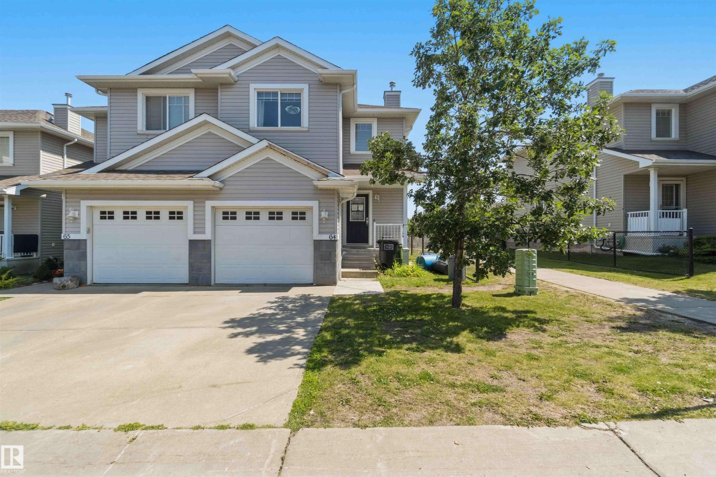 Contemporary two-story townhouse featuring light grey siding and white trim - #64 120 Magrath Rd Nw, Edmonton, AB - Outdoor With Facade