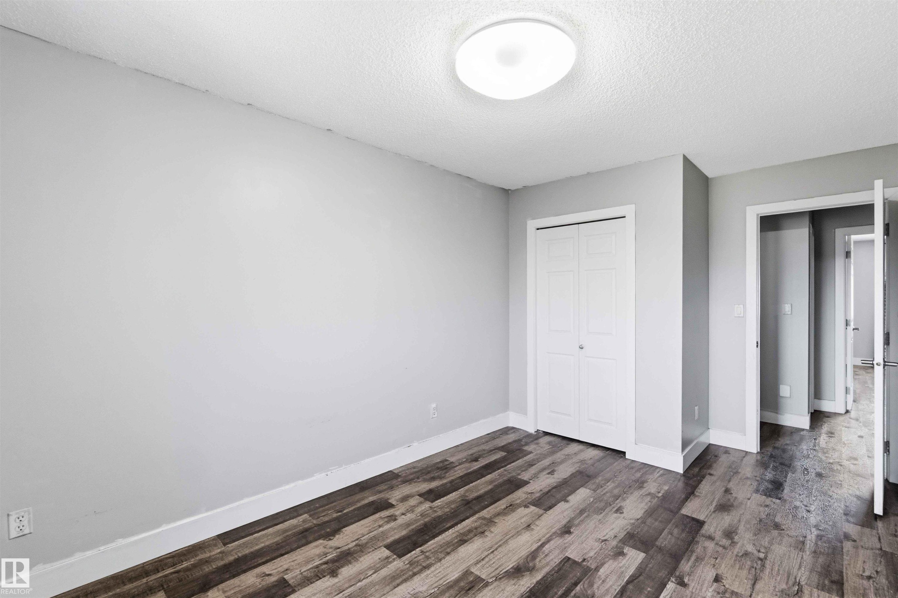 Room featuring neutral wall tones and wood-finish flooring - #64 120 Magrath Rd Nw, Edmonton, AB - Indoor Photo Showing Other Room
