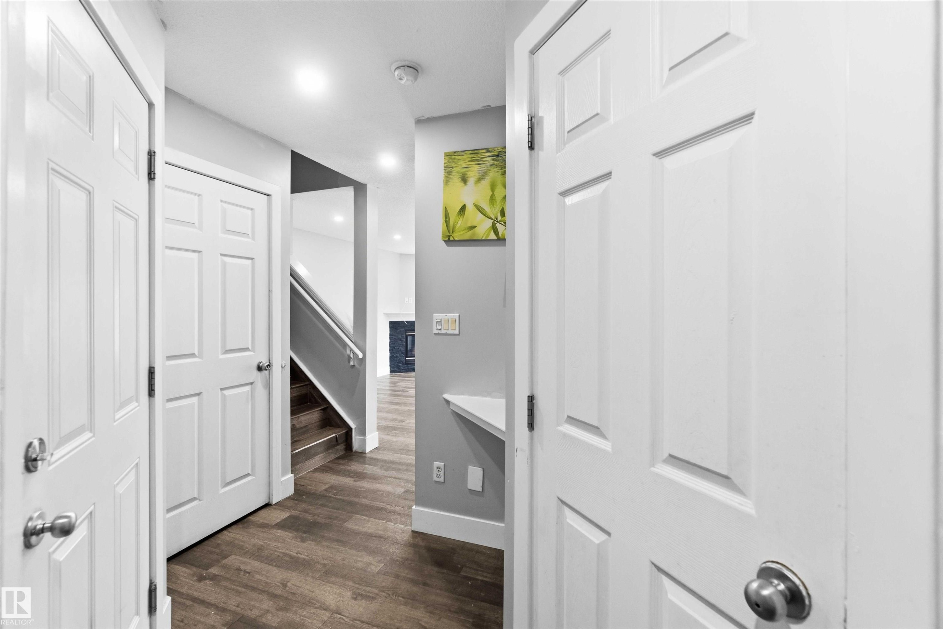 Hallway featuring wood-finish flooring, white paneled doors, and recessed lighting - #64 120 Magrath Rd Nw, Edmonton, AB - Indoor Photo Showing Other Room
