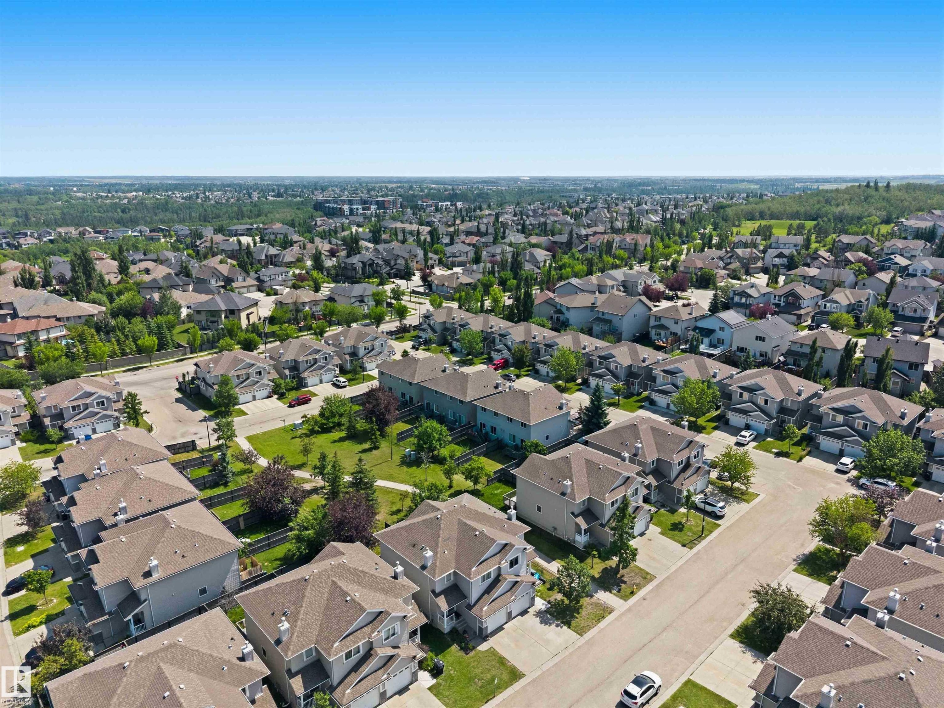 Expansive residential development featuring mature landscaping, paved streets, and varied architectural styles - #64 120 Magrath Rd Nw, Edmonton, AB - Outdoor With View