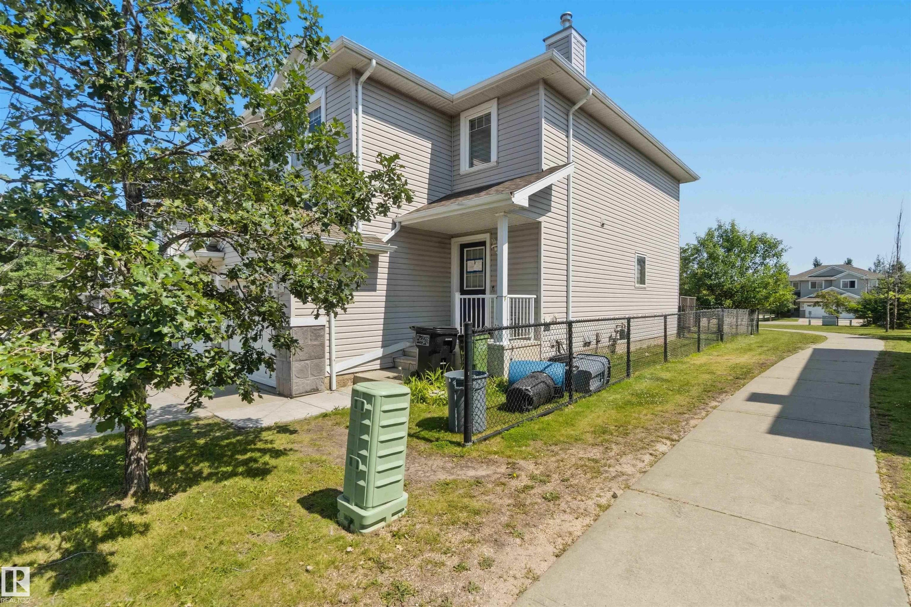 Two-story residence featuring light gray siding and stone accents - #64 120 Magrath Rd Nw, Edmonton, AB - Outdoor