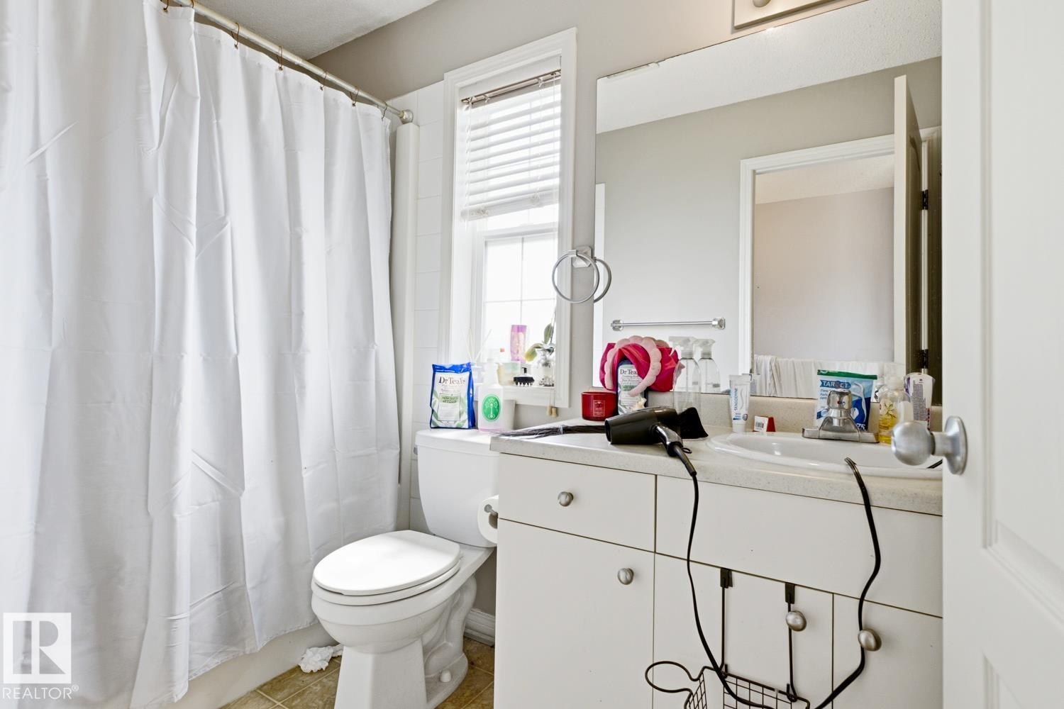 Bathroom featuring a single vanity with storage cabinetry, an integrated sink, and a rectangular mirror - 3724 163 Avenue Nw, Edmonton, AB - Indoor Photo Showing Bathroom