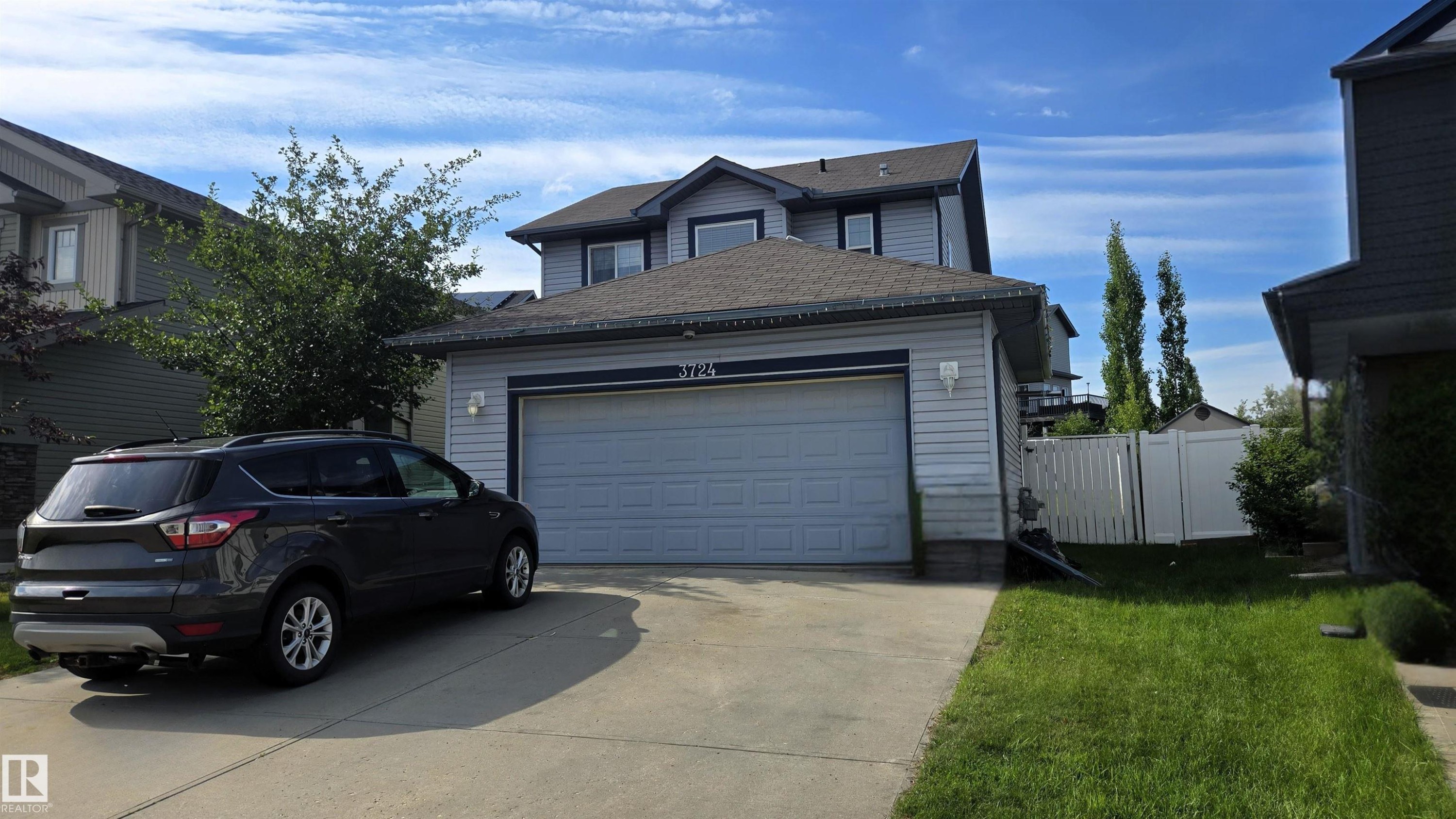 Two-story residence featuring light gray siding, a dark shingle roof, and an attached two-car garage - 3724 163 Avenue Nw, Edmonton, AB - Outdoor
