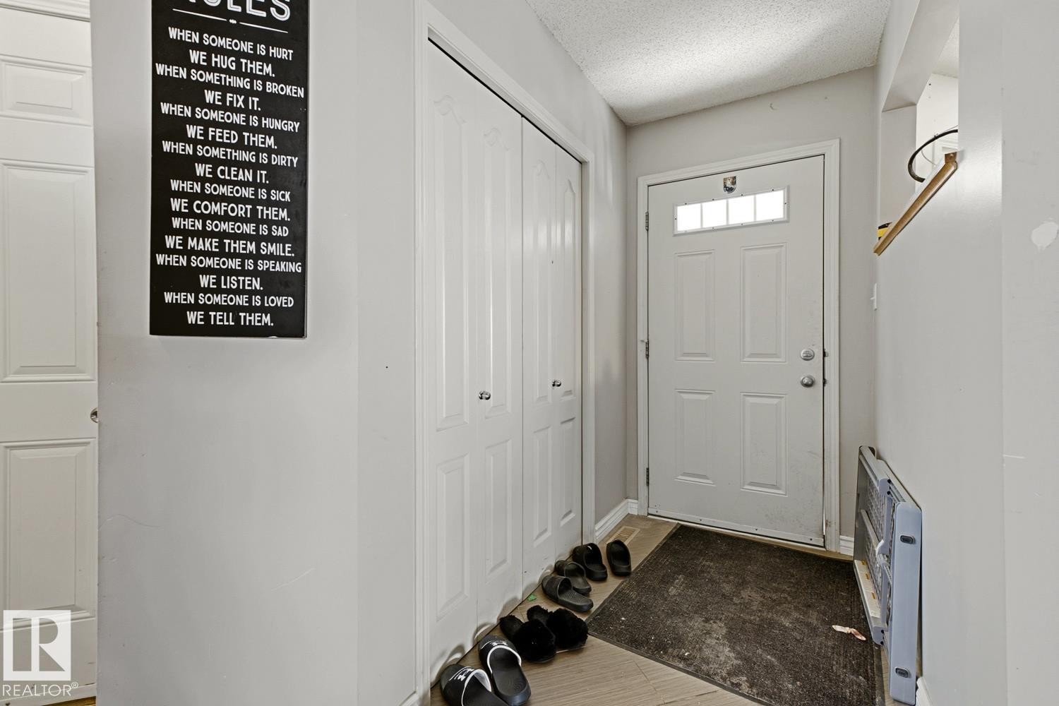 Entryway featuring a white paneled door with glass inserts, light grey wall paint, and wood-finish flooring - 3724 163 Avenue Nw, Edmonton, AB - Indoor Photo Showing Other Room