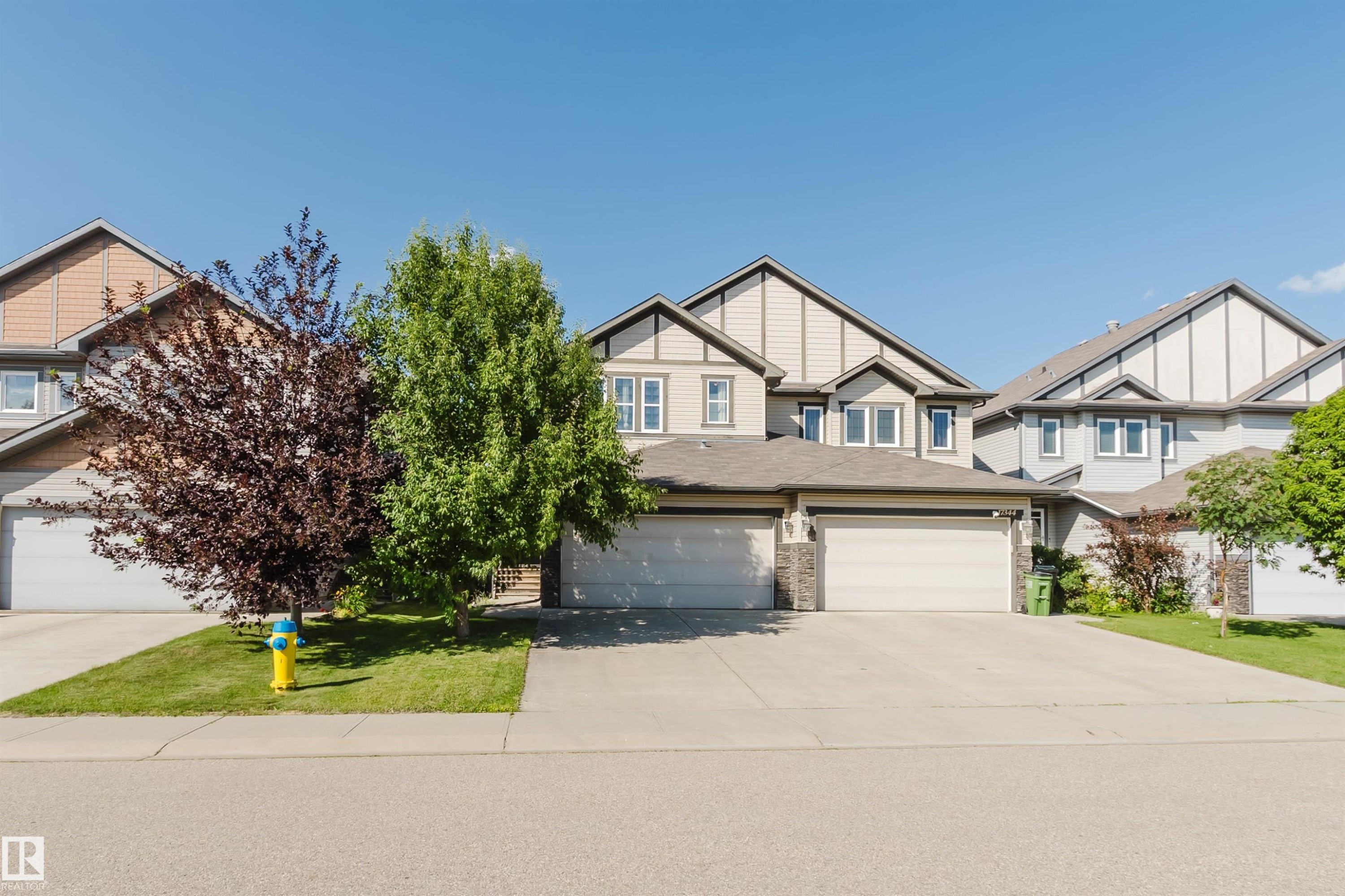 Contemporary two-story exterior with a two-car garage, stone accents, and a concrete driveway - 17348 6 Avenue Sw, Edmonton, AB - Outdoor With Facade