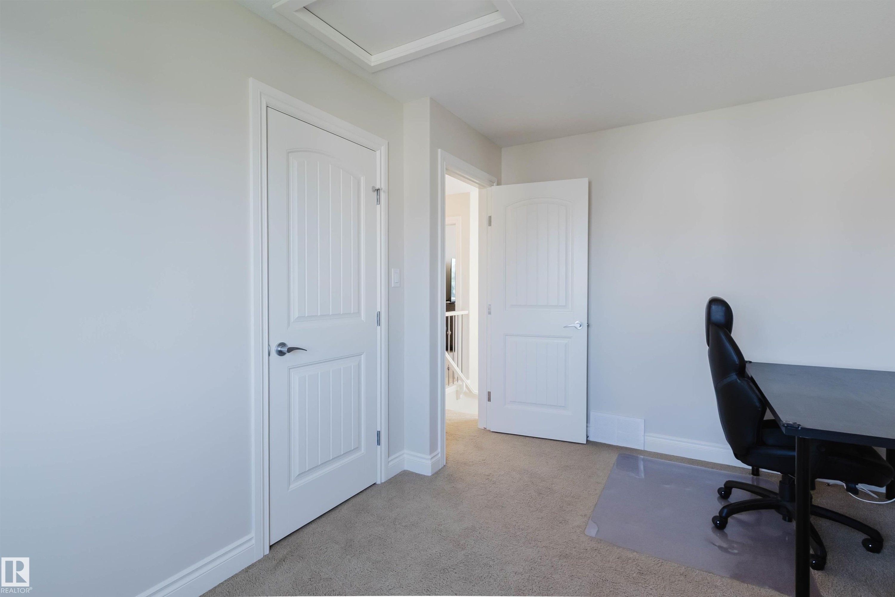 Neutral wall color with white trim, two panel doors, and carpeting - 17348 6 Avenue Sw, Edmonton, AB - Indoor Photo Showing Other Room