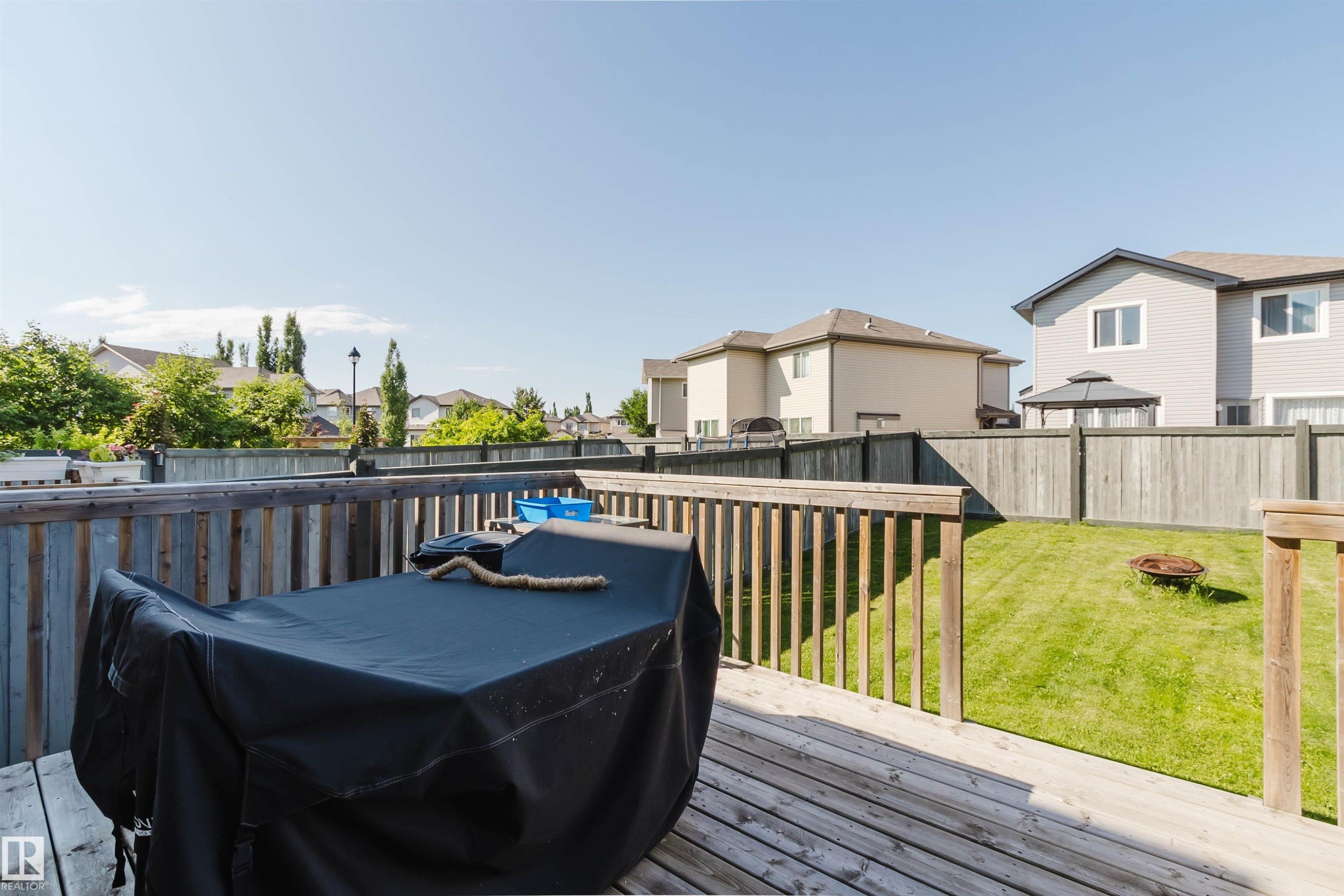 Wood-plank deck with a wood railing overlooking a fenced backyard - 17348 6 Avenue Sw, Edmonton, AB - Outdoor With Deck Patio Veranda With Exterior