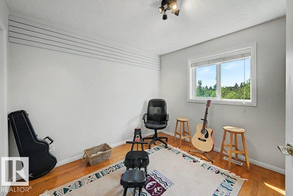 Bright room featuring wood-finish flooring and a single window with blinds - #39 2419 133 Av Nw, Edmonton, AB - Indoor