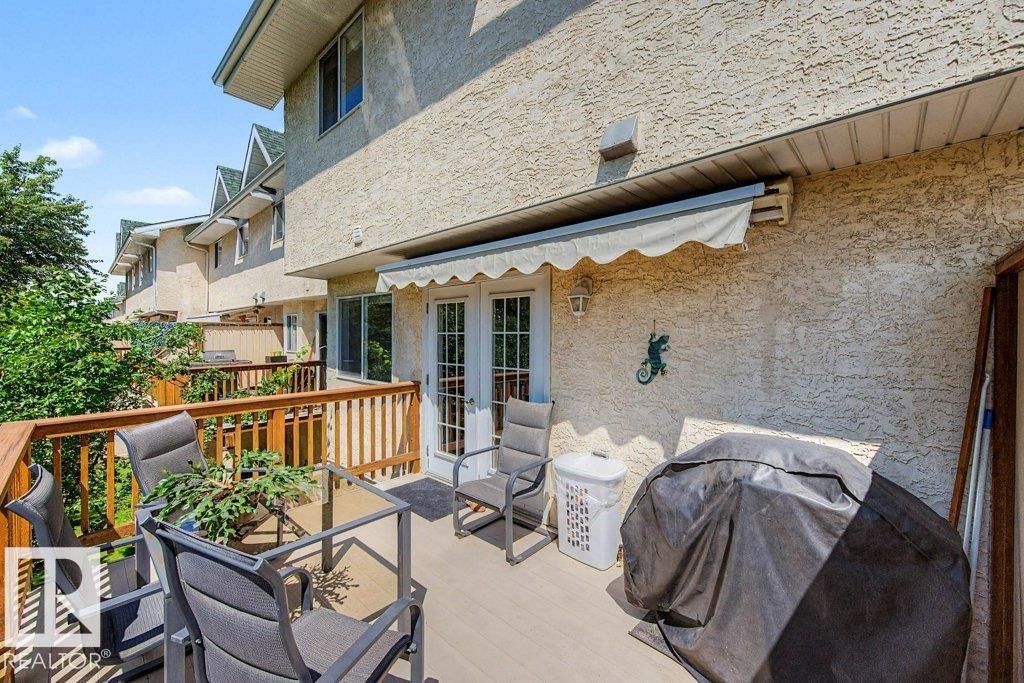 Spacious outdoor deck featuring wood-finish railing and privacy fencing - #39 2419 133 Av Nw, Edmonton, AB - Outdoor With Deck Patio Veranda With Exterior