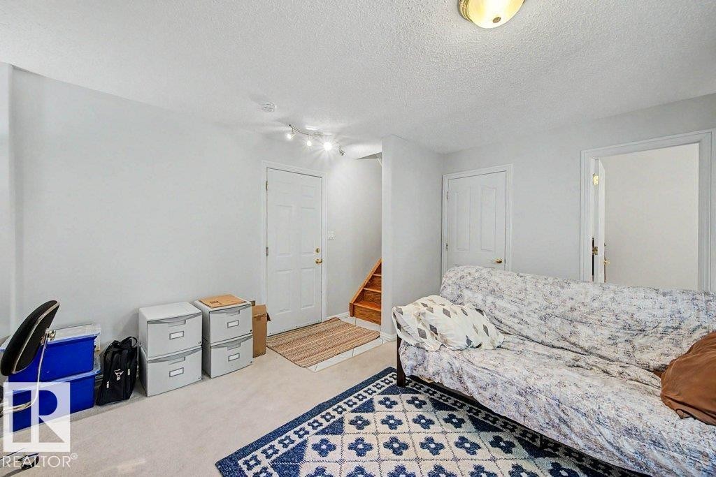 Carpeted room with light-colored walls and a track lighting fixture - #39 2419 133 Av Nw, Edmonton, AB - Indoor Photo Showing Bedroom