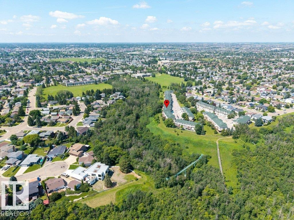 Residential neighborhood featuring mature trees, green spaces, and a winding path - #39 2419 133 Av Nw, Edmonton, AB - Outdoor With View