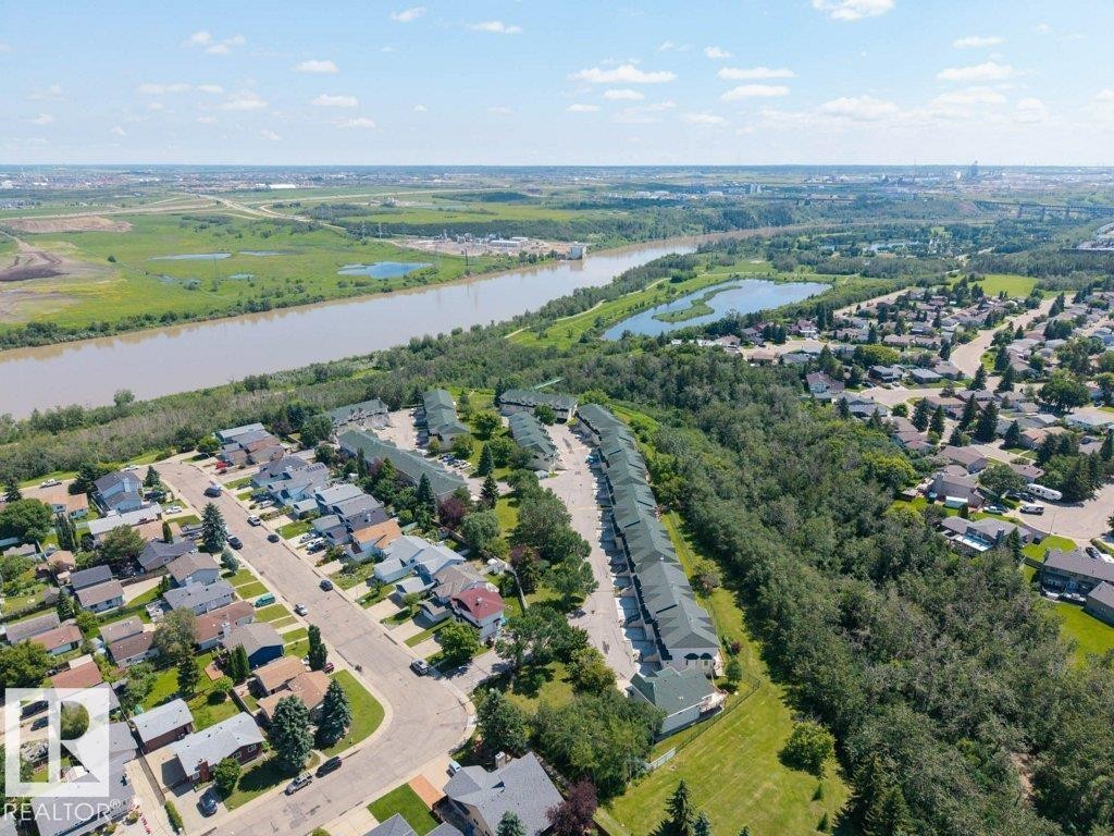 Aerial perspective showcasing a residential community situated alongside a river - #39 2419 133 Av Nw, Edmonton, AB - Outdoor With View
