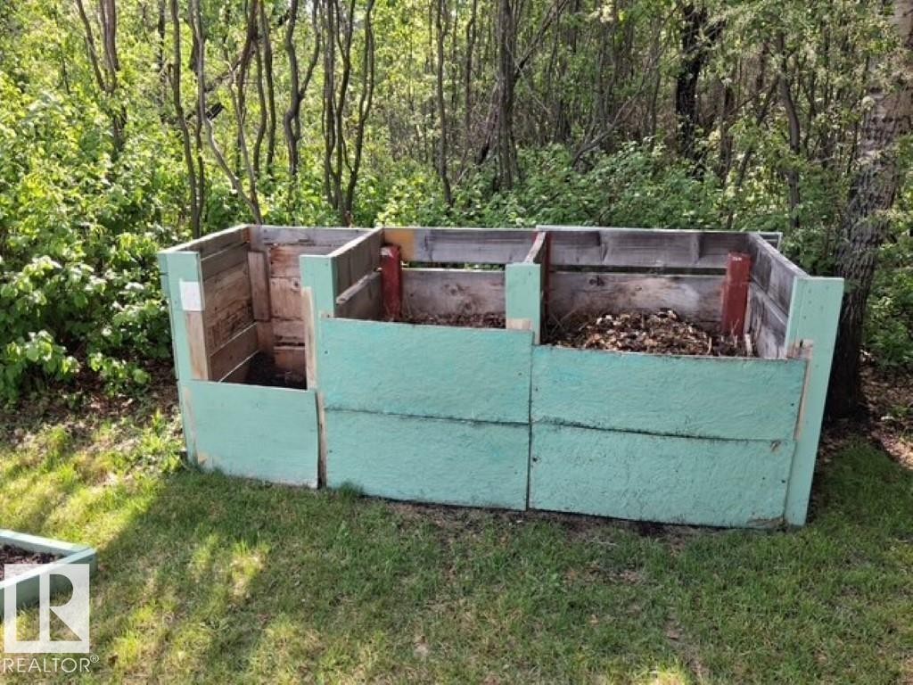 Three-bin compost system featuring painted wood construction, integrated into a natural, treed setting - 204 Sandy Beach Way, Rural Two Hills County, AB - Outdoor