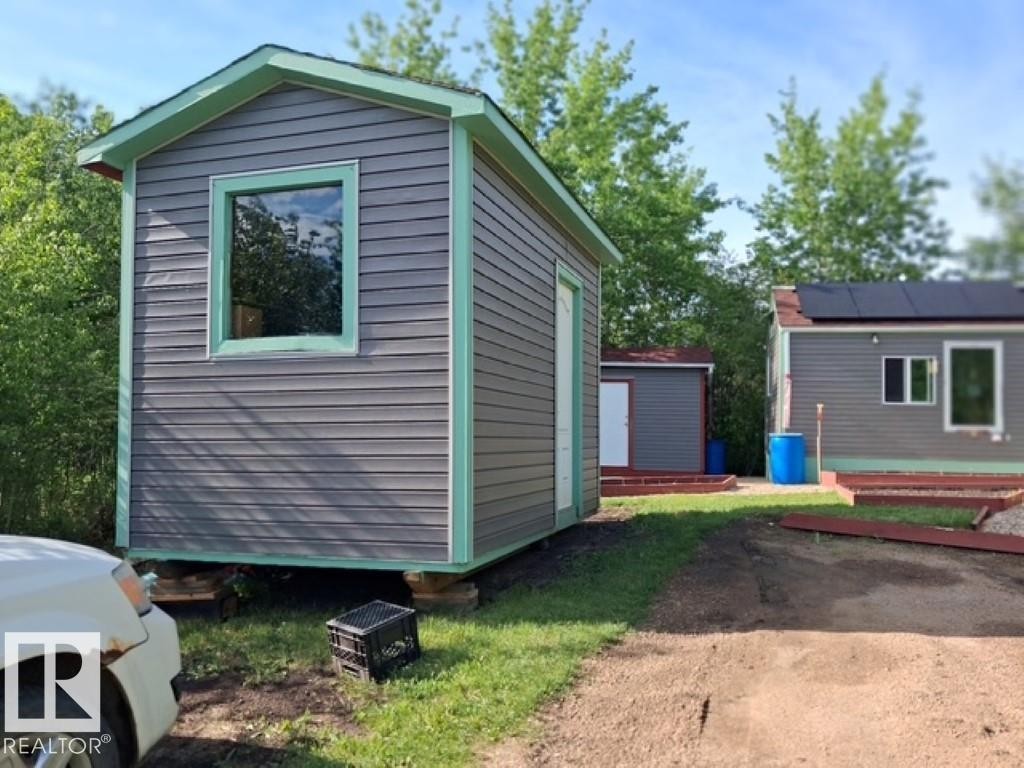 Compact structure with grey horizontal siding and light green trim - 204 Sandy Beach Way, Rural Two Hills County, AB - Outdoor With Exterior