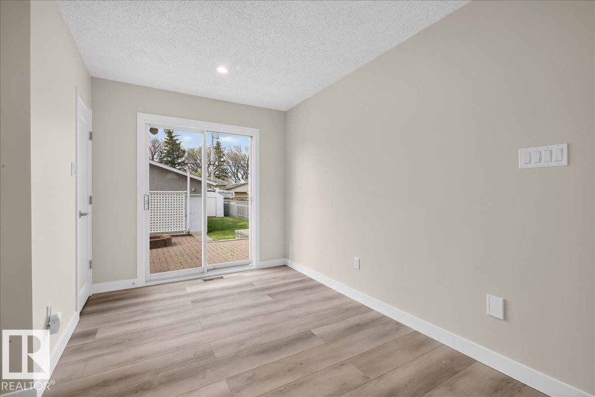 Sliding glass doors opening to an exterior patio with a brick paver surface - 9723 65 Avenue Nw, Edmonton, AB