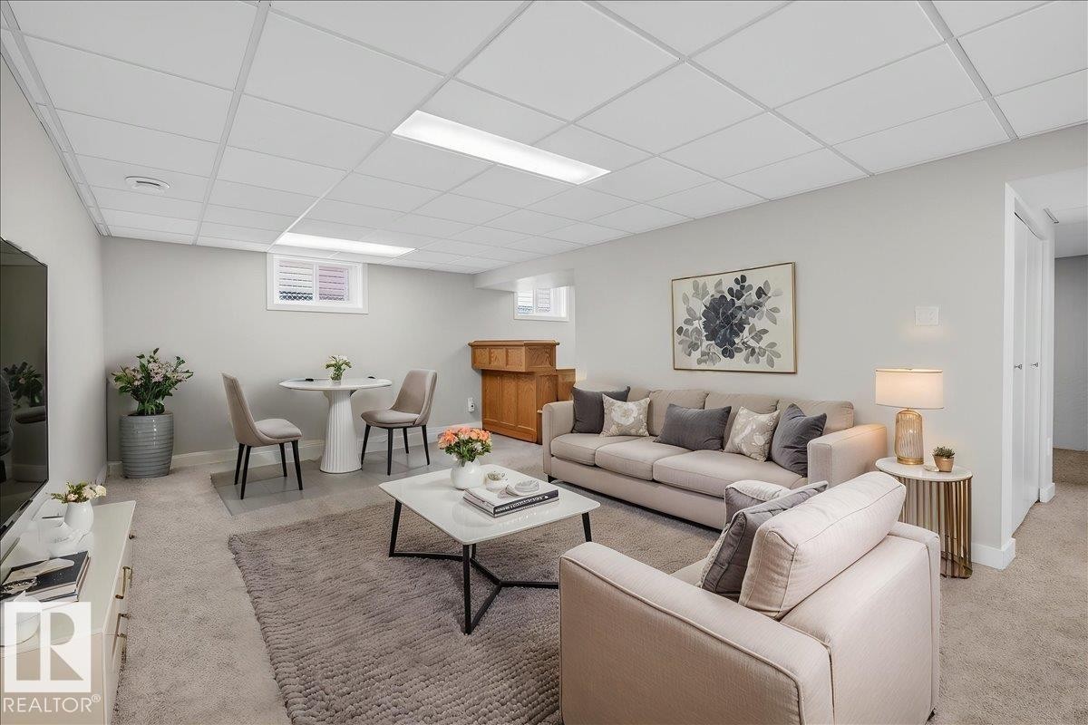 Spacious lower-level area featuring light gray wall paint, recessed lighting, and carpet flooring - 9723 65 Avenue Nw, Edmonton, AB