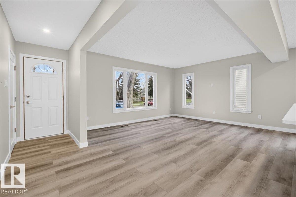 Expansive living space featuring wood-finish flooring and neutral wall tones - 9723 65 Avenue Nw, Edmonton, AB
