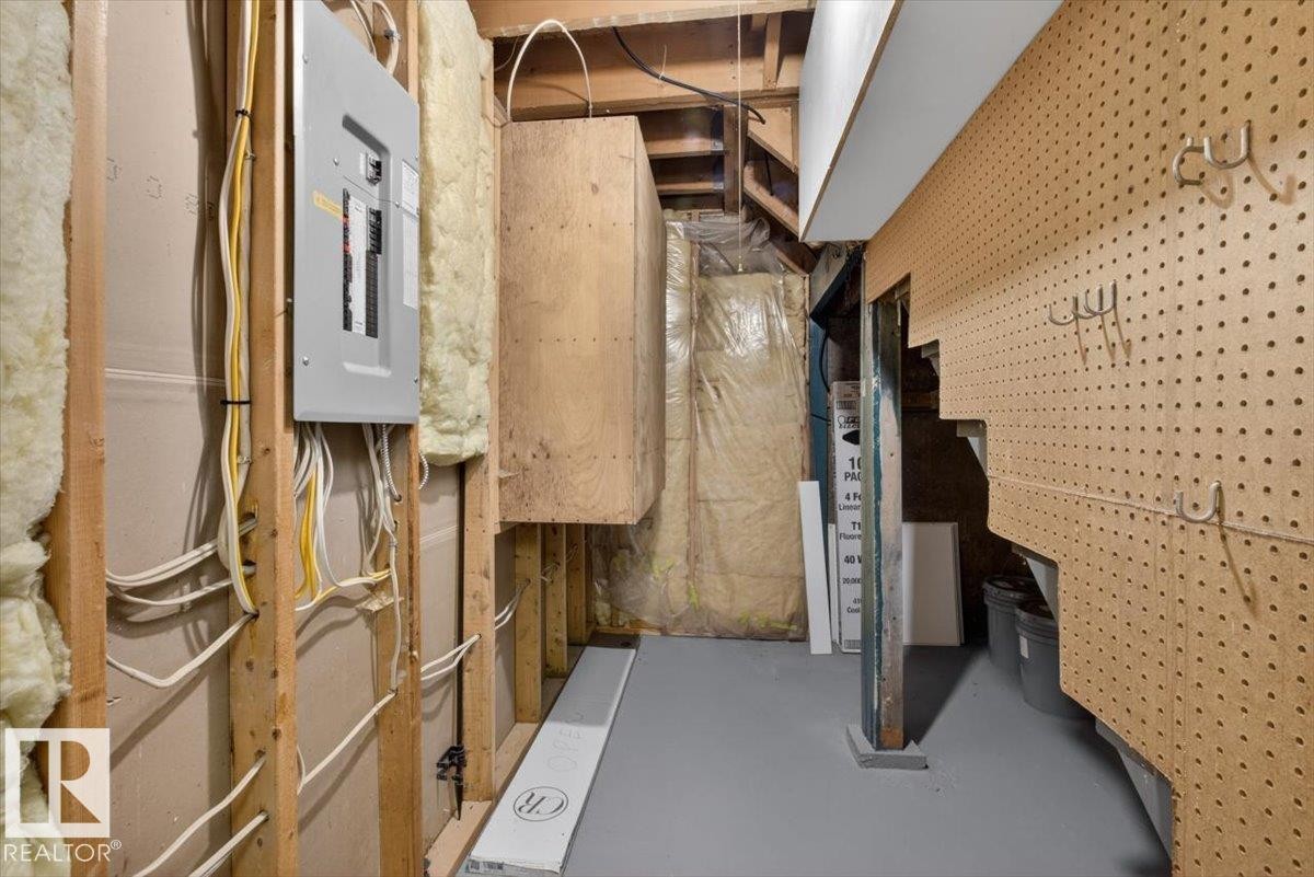 Utility area featuring a circuit breaker panel, exposed wood framing, and insulation - 9723 65 Avenue Nw, Edmonton, AB
