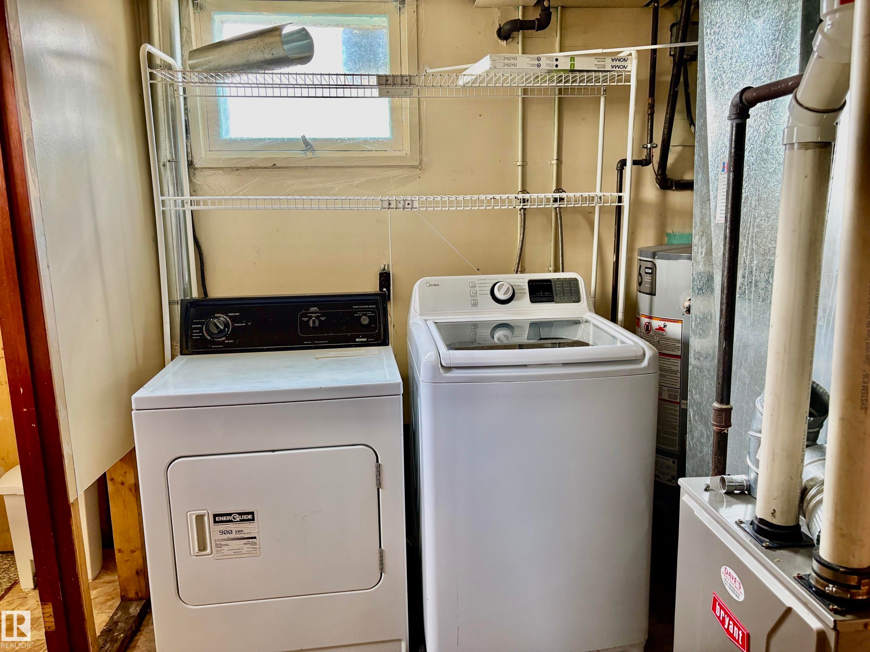 Dedicated laundry area with a white top-load washing machine and a white front-load dryer - 5206 51Ave, Willingdon, AB - Indoor Photo Showing Laundry Room