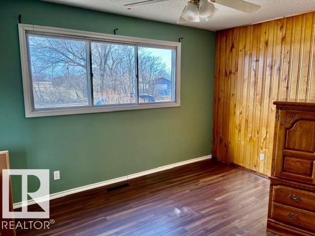Interior room featuring wood-finish flooring and a wood paneled accent wall - 5206 51Ave, Willingdon, AB - Indoor Photo Showing Other Room