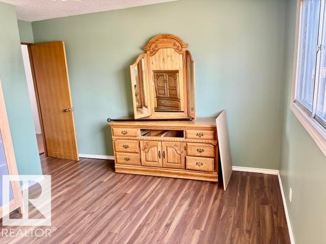 Interior space featuring wood-finish flooring, light green painted walls, white baseboards, and a white ceiling - 5206 51Ave, Willingdon, AB - Indoor