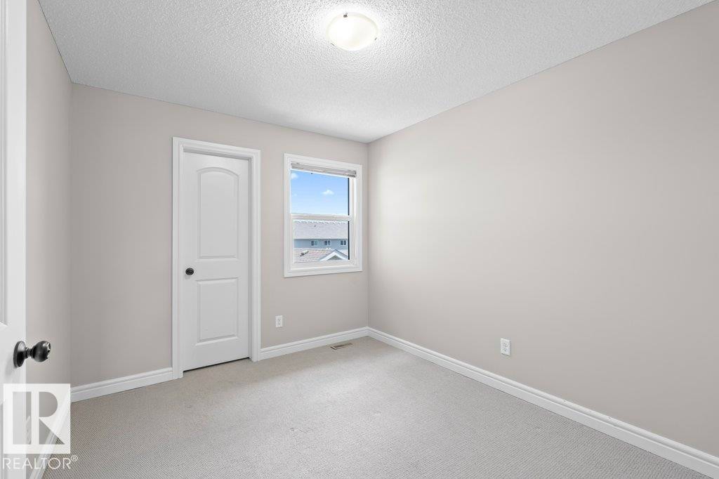 Bright room with neutral grey wall paint, plush grey carpet, and white baseboards - 1627 167 Street Sw, Edmonton, AB - Indoor Photo Showing Other Room