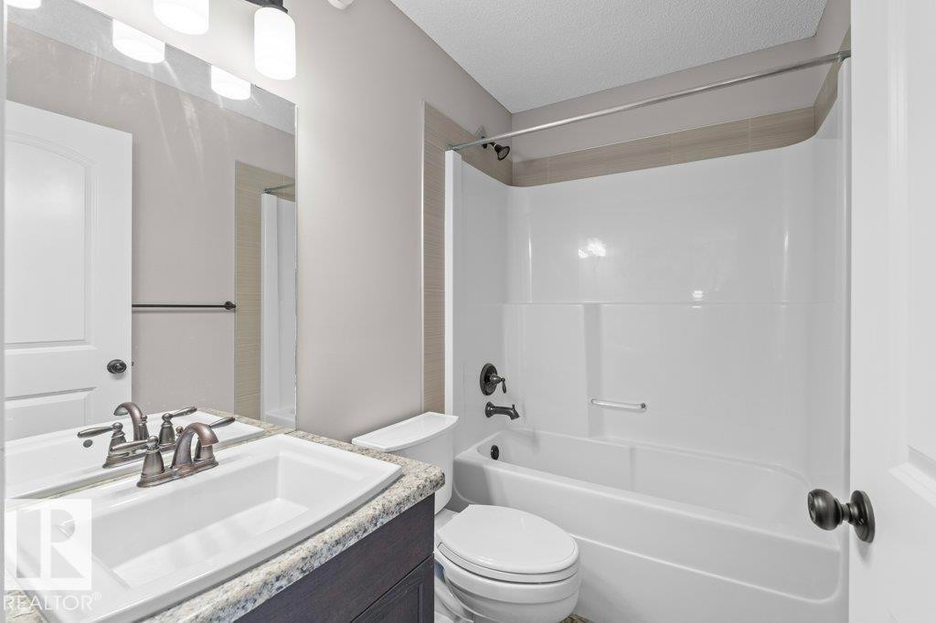 Bathroom featuring a white integrated sink, speckled countertop, and dark wood-finish vanity with cabinet storage - 1627 167 Street Sw, Edmonton, AB - Indoor Photo Showing Bathroom