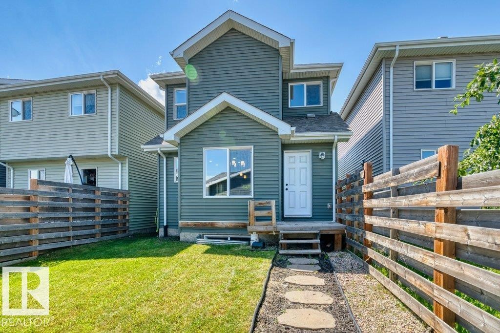 Two-story home featuring a teal siding exterior, white trim, and a white entry door - 1627 167 Street Sw, Edmonton, AB - Outdoor