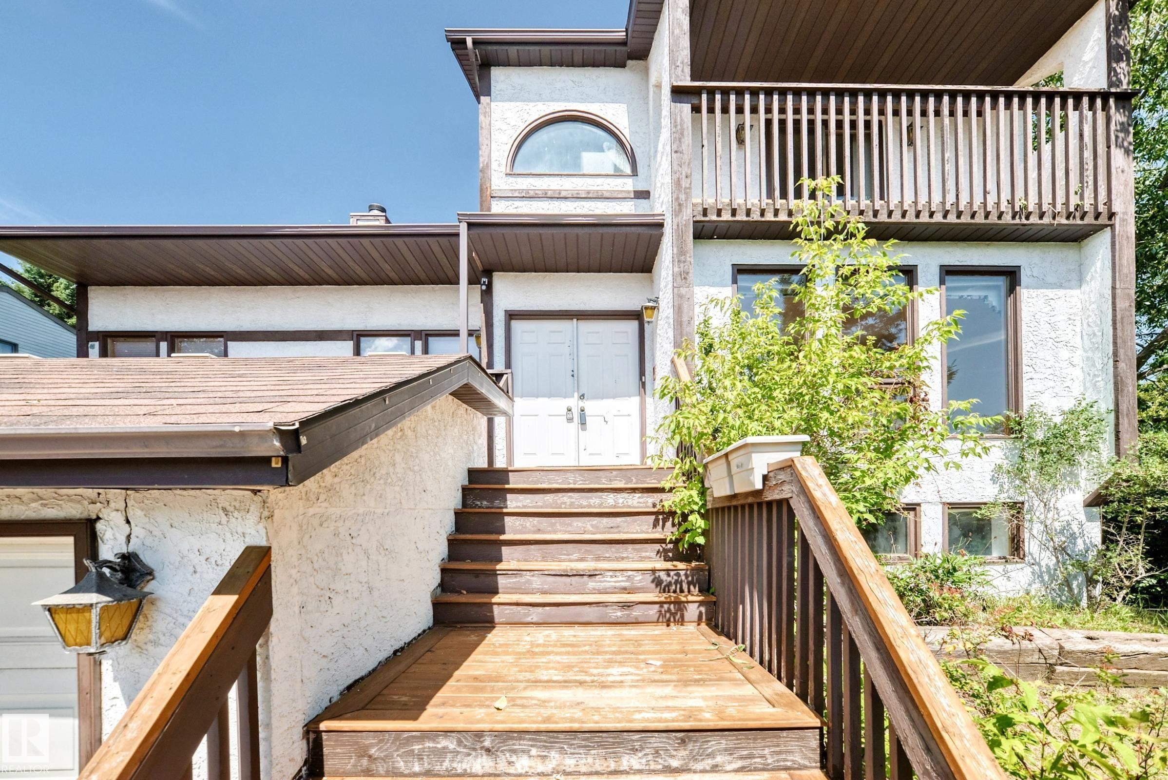 Multi-level exterior featuring white stucco siding and dark trim - 4208 Ramsay Road Nw, Edmonton, AB - Outdoor With Exterior
