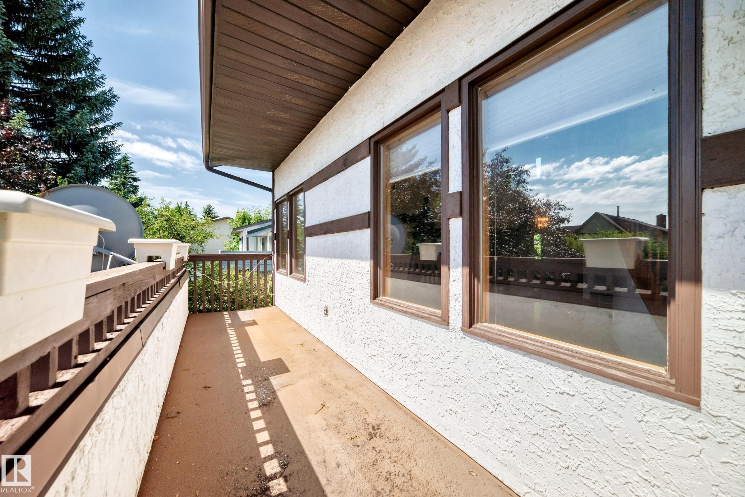 Balcony with concrete flooring and brown wood railing - 4208 Ramsay Road Nw, Edmonton, AB - Outdoor With Exterior