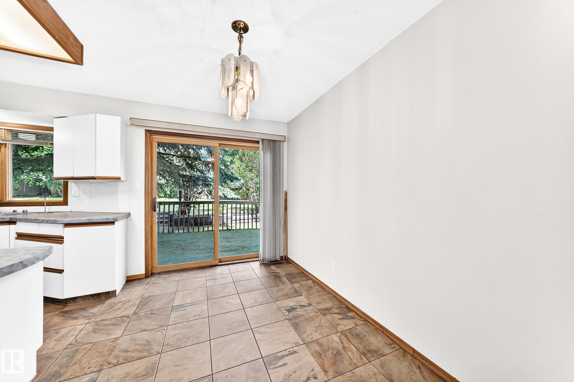 Sliding glass door opening to an exterior deck and green space - 4208 Ramsay Road Nw, Edmonton, AB - Indoor