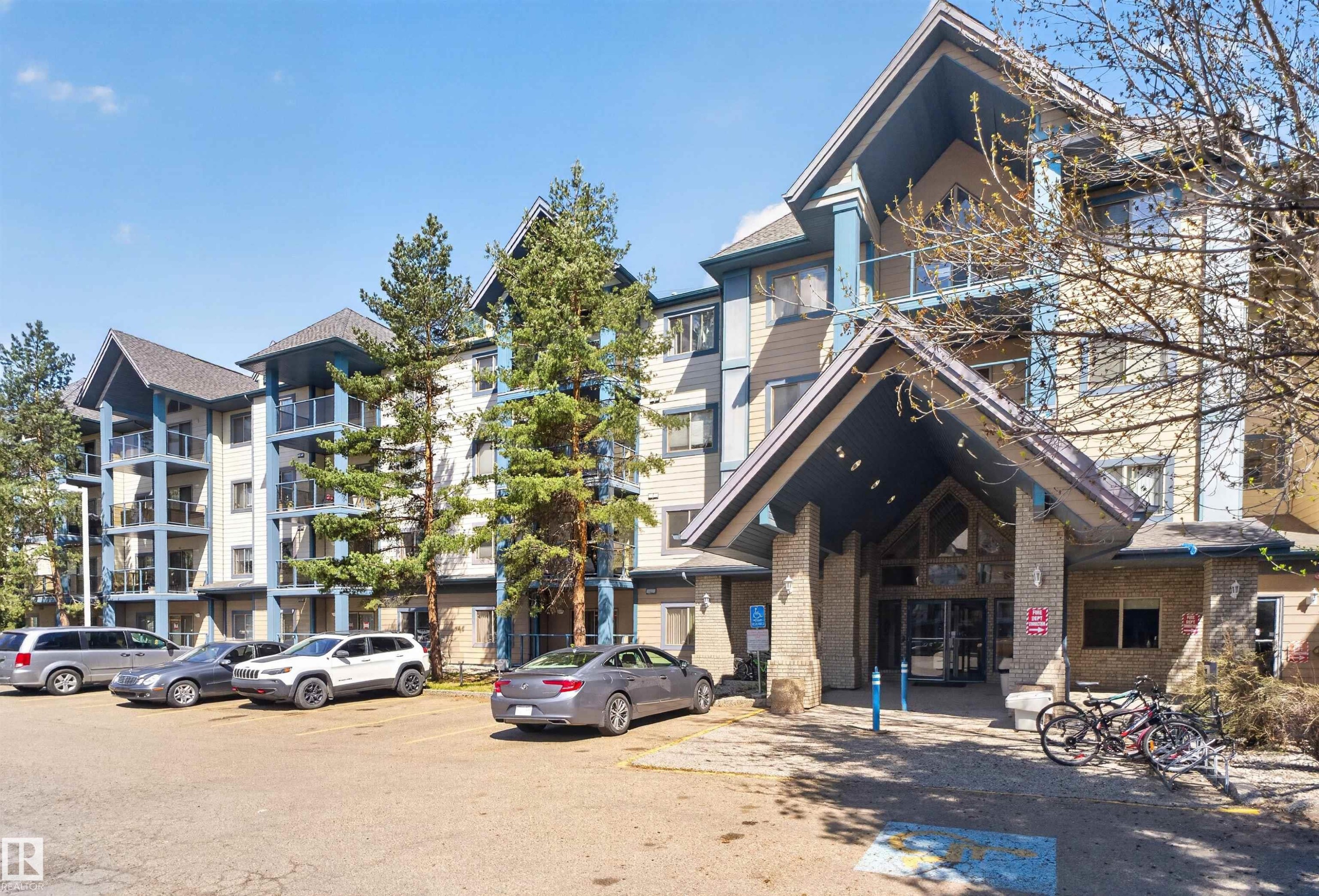 Multi-story residential building featuring a stone and siding exterior - #110 2903 Rabbit Hill Rd Nw, Edmonton, AB - Outdoor With Facade
