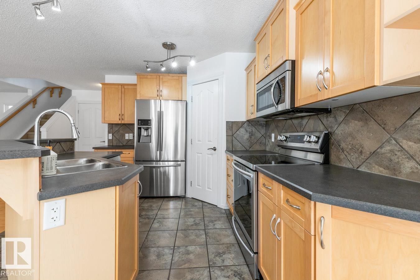 Kitchen With Stainless Steel Appliances. - 4717 60 Street, Beaumont, AB