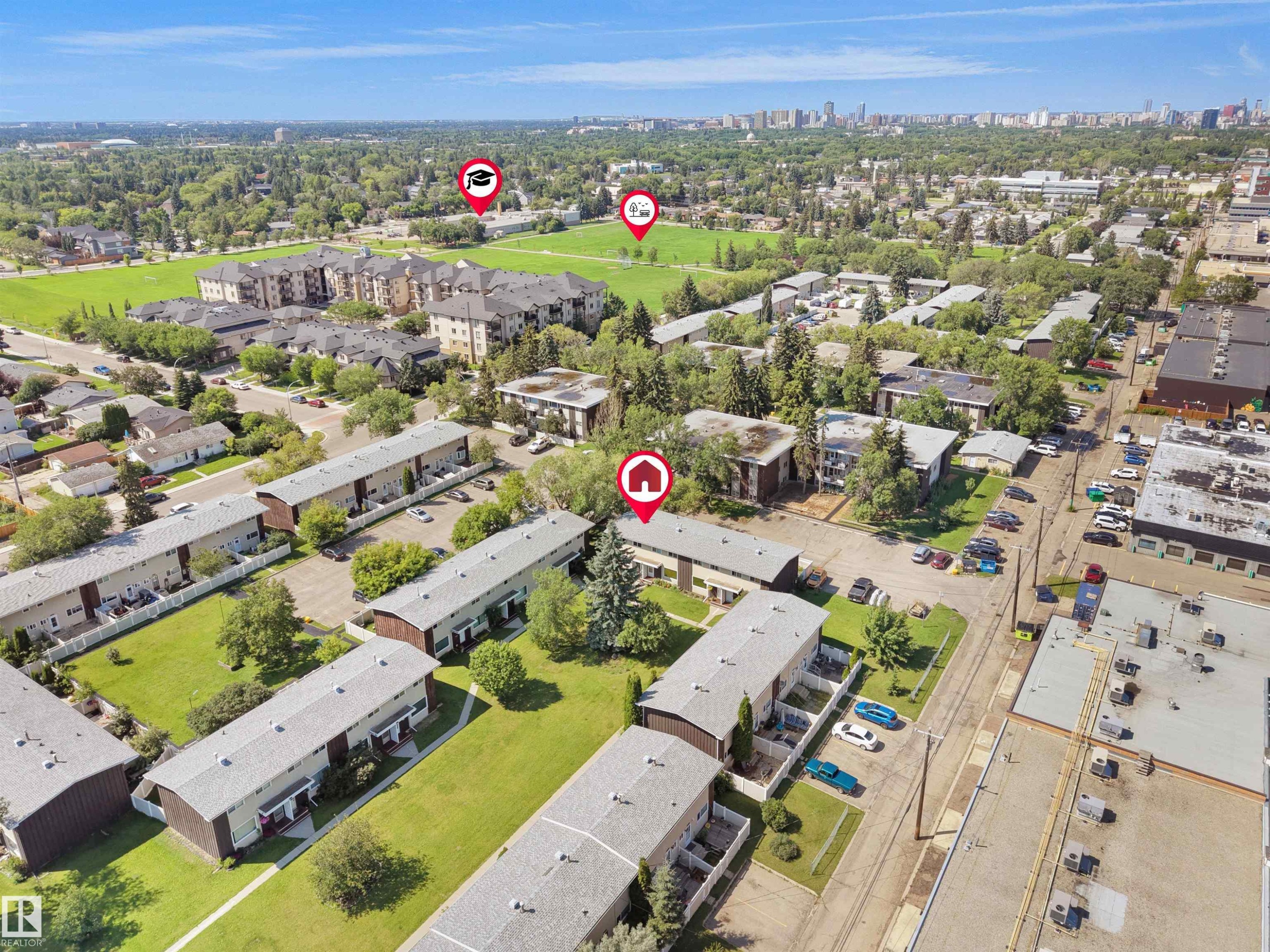 Aerial perspective of a multi-building residential complex surrounded by green spaces and mature trees - 10446 55 Avenue Nw, Edmonton, AB - Outdoor With View