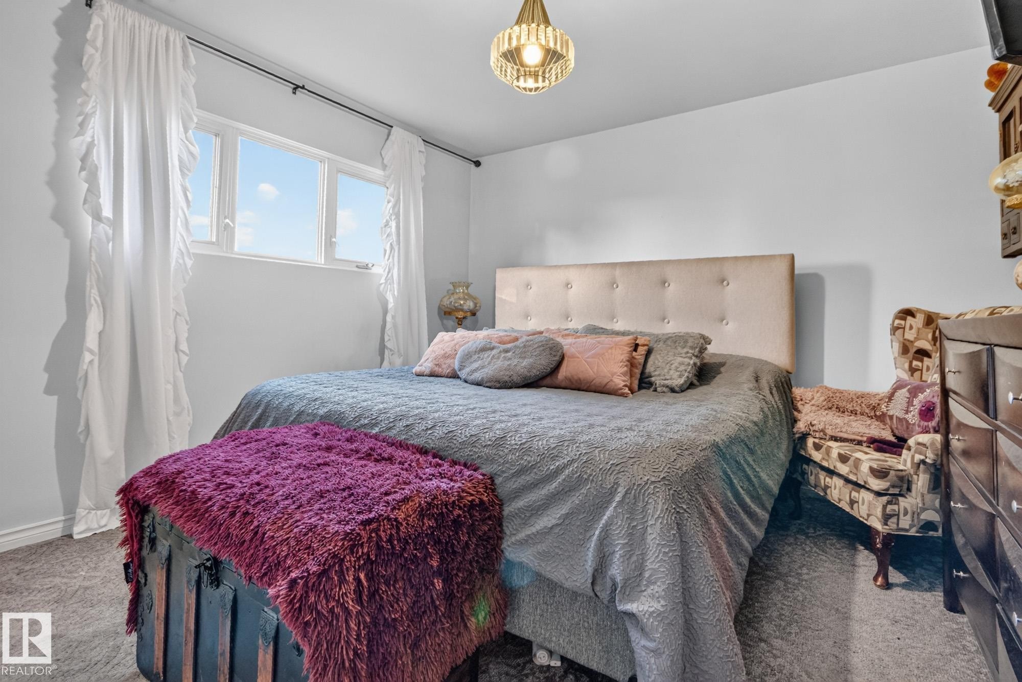 Bright interior space with light gray walls, light gray carpet flooring, and a multi-pane window - 5307 104 Avenue Nw, Edmonton, AB - Indoor Photo Showing Bedroom